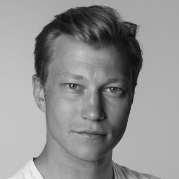 Mustavalkoinen muotokuva nuoresta miehestä, jolla on lyhyet vaaleat hiukset ja joka katsoo suoraan kameraan neutraalilla ilmeellä. Hänellä on yllään vaalea paita tavallista taustaa vasten.