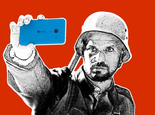 Toisen maailmansodan aikaiseen sotilaskypärään ja univormuun pukeutunut mies pitää kirkkaan sinistä älypuhelinta kädessään ja ottaa selfietä yhtenäistä punaista taustaa vasten. Kuva on osittain tyylitelty mustavalkoiseksi.