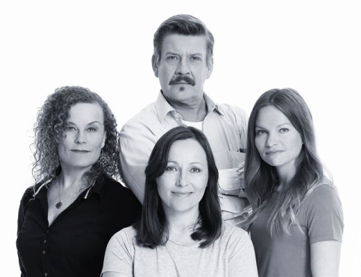 Mustavalkoinen valokuva neljästä aikuisesta, jotka poseeraavat yhdessä; yksi viiksekäs mies seisoo kolmen naisen takana, joilla on erilaiset hiustyylit ja jotka ovat kameraan päin, kaikki neutraalisti tai lievästi hymyillen.