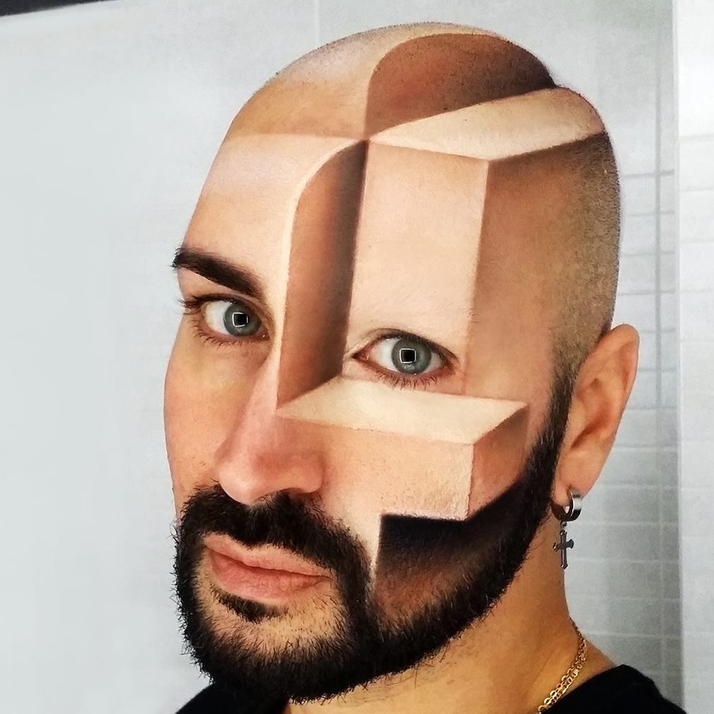 Parran ja parran ajaneen henkilön kasvoihin ja päänahkaan on maalattu realistisia geometrisia 3D-muotoja, jotka luovat optisen illuusion. Henkilöllä on ristikorvakoru ja hän katsoo suoraan kameraan.