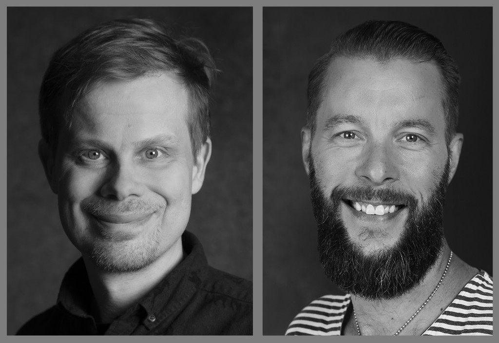 Mustavalkoinen muotokuva kahdesta hymyilevästä miehestä; vasemmalla olevalla miehellä on lyhyet hiukset eikä partaa, kun taas oikealla olevalla miehellä on täysparta ja hänellä on raidallinen paita.