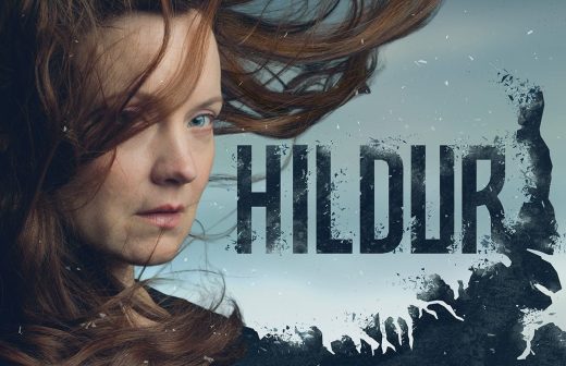 Nainen, jolla on pitkät ruskeat hiukset, joita tuuli puhaltaa, seisoo isoilla, lihavoituneilla kirjaimilla kirjoitetun sanan HILDUR vieressä, ja tekstin osana on henkilön siluetti ja myrskyävät aallot.